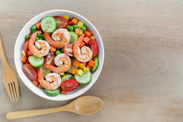 top view of shrimps salad in with sesame soy sauce in a ceramic bowl on wooden table. homemade style food concept.