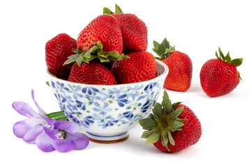 large ripe red strawberries in a pretty blue pattern bowl isolated on white