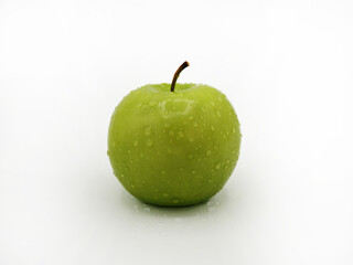 A single green apple with water droplets