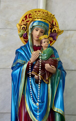 Fototapeta na wymiar Closeup of Our lady of perpetual help statue virgin Mary with Child Jesus in the church, Thailand. selective focus.