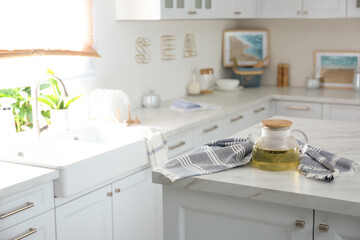 Teapot and towel on white marble table in modern kitchen. Interior design