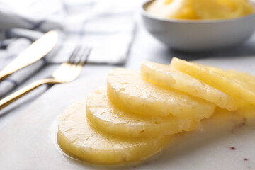 Delicious canned pineapple rings on marble board, closeup