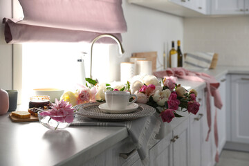 Beautiful peonies and breakfast on kitchen counter