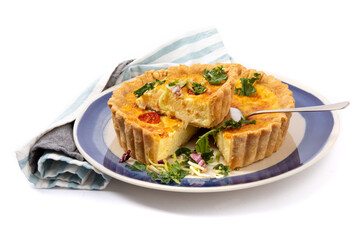 a cheese quiche with dried tomatoes with one piece cut out ready to serve isolated on white

