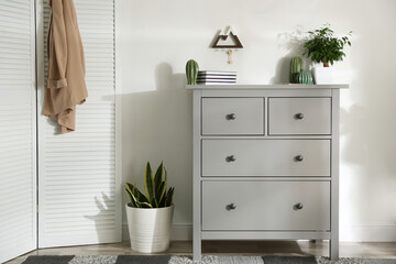 Grey chest of drawers in stylish room interior