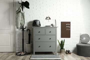 Grey chest of drawers in stylish hallway interior