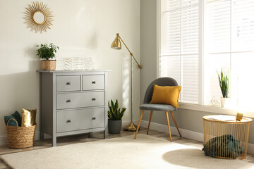 Grey chest of drawers in stylish room interior