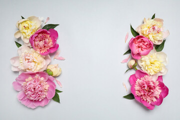 Beautiful fresh peonies and leaves on light grey background, flat lay. Space for text