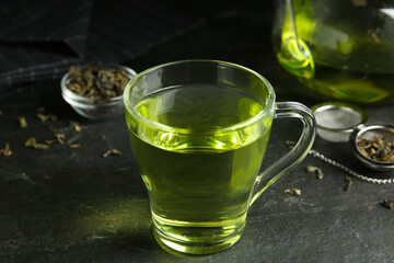 Cup of aromatic green tea on grey table
