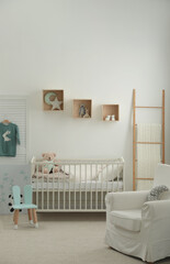 Stylish baby room interior with crib and armchair