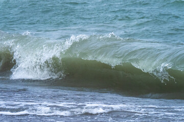 a large wave breaking on a shore with the underside of the curl visible