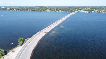 Image of Highway road spanning through lake during clear summer weather