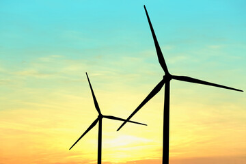 Silhouettes of wind turbines at sunset. Alternative energy source