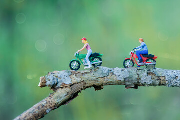 Miniature figures rider  motor cycle in tropical garden 