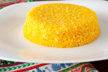 tasteful and colorful brazilian corn couscous on a wooden table