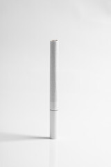 White cigarette standing on white background