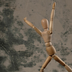 Puppet in the hands of puppeteer walks on isolated, background. The concept of manipulation. Copy space.