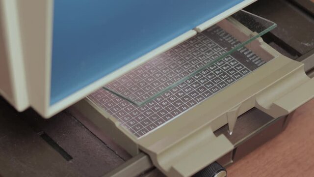 Man using microfiche reader to research archived documents