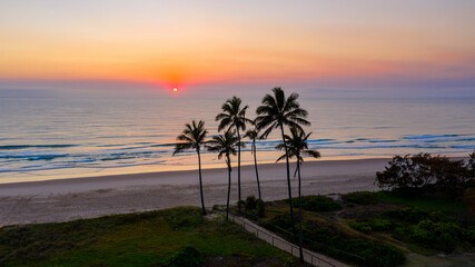 Obraz na płótnie Canvas Ocean sunrise with palm tree's by the beach, Main beach Gold Coast.