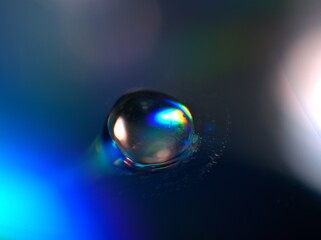 blurred water droplets with blue light on black backgronud, dark and shiny , abstract background, macro image for card design