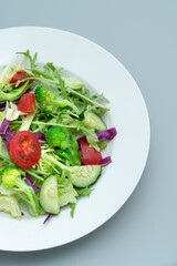 Close-up of a plate of delicious healthy green vegetable salad.