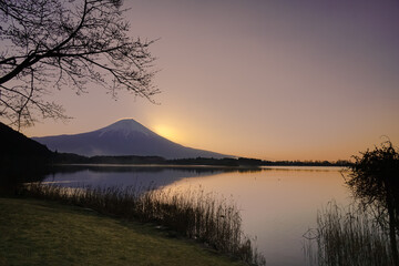 Mt fuji view from a boat ramp on a lake in the early morning sunrise there is some fog and hazeadding to the image