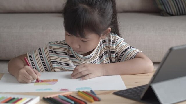 Education. Asian little girl learning and drawing with online teacher on tablet 