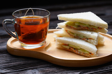 Hot Tea with Tuna Sandwich on wooden plate