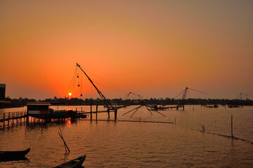 Fototapeta na wymiar Silhouette of chinese fishing nets in kochi backwaters during sunset.