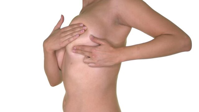 Woman checking her nude breast for signs of breast cancer. Zoom in.