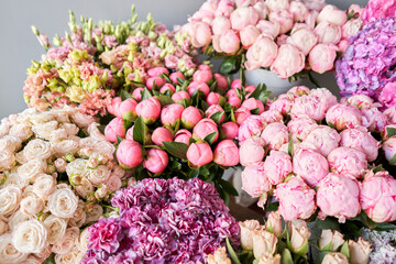 Many different colors on the stand or wooden table in the flower shop. Showcase. Background of mix of flowers. Beautiful flowers for catalog or online store. Floral shop and delivery concept. Top view