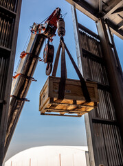 The crane carrying a wooden box of radioactive instrument holder to the high floor of the plant