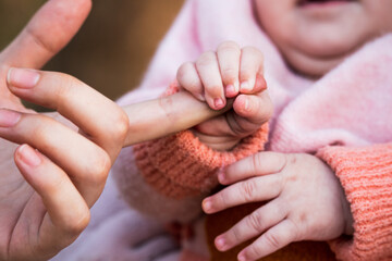 Closeup of a newborn baby's hand holding mother's finger.