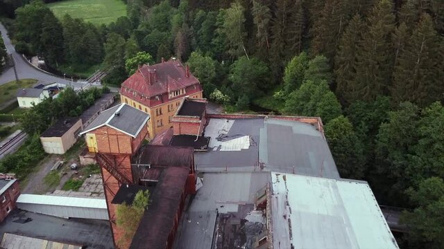Aerial view of a demolished roof of a socialist lost place factory in eastern Germany filmed with drone viewing down