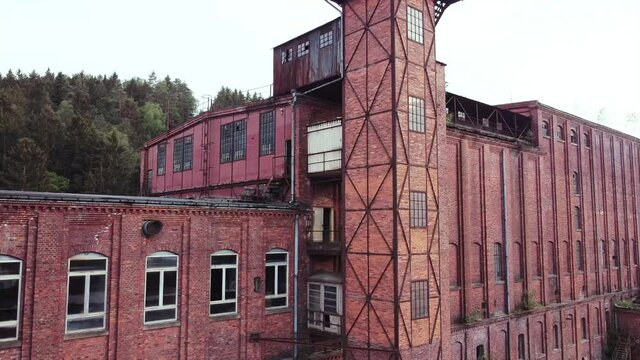 Close flight of a drone flying upwards with view on an old lost place socialist factory in the middle of Europe