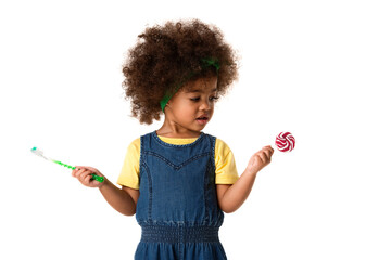childhood and people concept- lovely african american little girl with toothbrush and sweet lolipop. Healthy teeth concept. Unhealthy food.