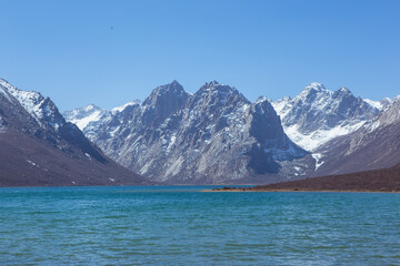 Nianbaoyuze, A sacred lake in Tibet with green water and snow mountains in the back.