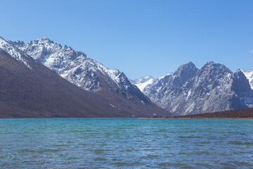 Nianbaoyuze, A sacred lake in Tibet with green water and snow mountains in the back.