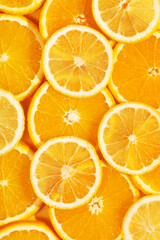 Top view of tasty slices of orange and lemon. Bright summer background. Healthy food. Proper nutrition. Fresh juices. Copy space, flat lay. Backdrop texture of fruits. Citrus products concept