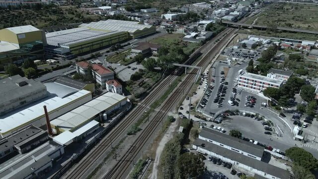 Drone Shot of a Train Passing in the Middle of the City during Day Time.