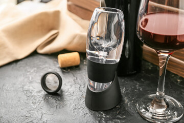 Aerator and glass of wine on dark background