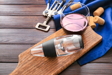 Aerator with glass of wine on wooden background