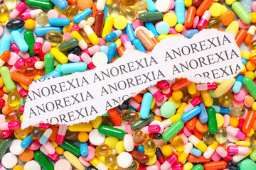 Piece of paper with text ANOREXIA on pills