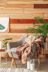 Armchair with plaid and table in modern room
