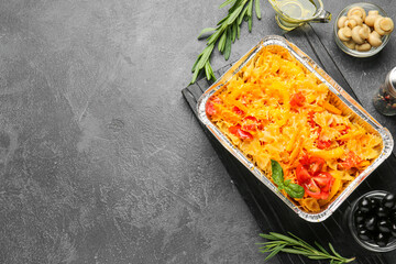 Tasty baked pasta in dish on dark background