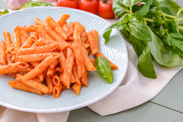 Plate with tasty pasta and tomato sauce on table