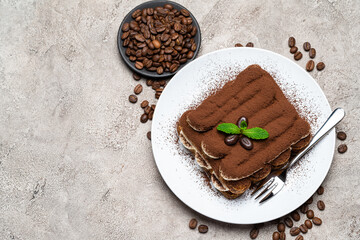 Classic tiramisu dessert on ceramic plate on concrete background