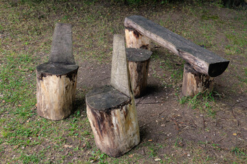 Obraz premium Wooden rustic log seats. Old bench and chairs from the array.