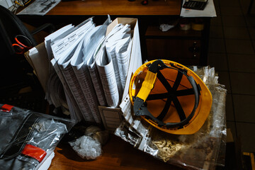 Yellow work helmet lying on a table with offic