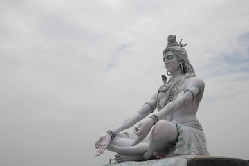 Obraz premium RISHIKESH, INDIA , Statue of Shiva, Hindu idol near Ganges River water, Rishikesh, India. The first Hindu God Shiva. Sacred places for pilgrims in Rishikesh